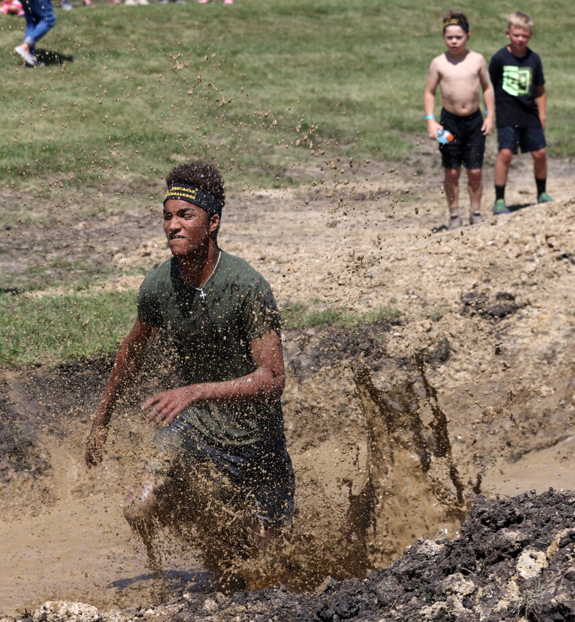 A competitor hits the mud pit obstacle during the 14-18-year-olds' race in the TriForHealth obstacle event during the Jackson County Fair Saturday at the Jackson Motorplex.