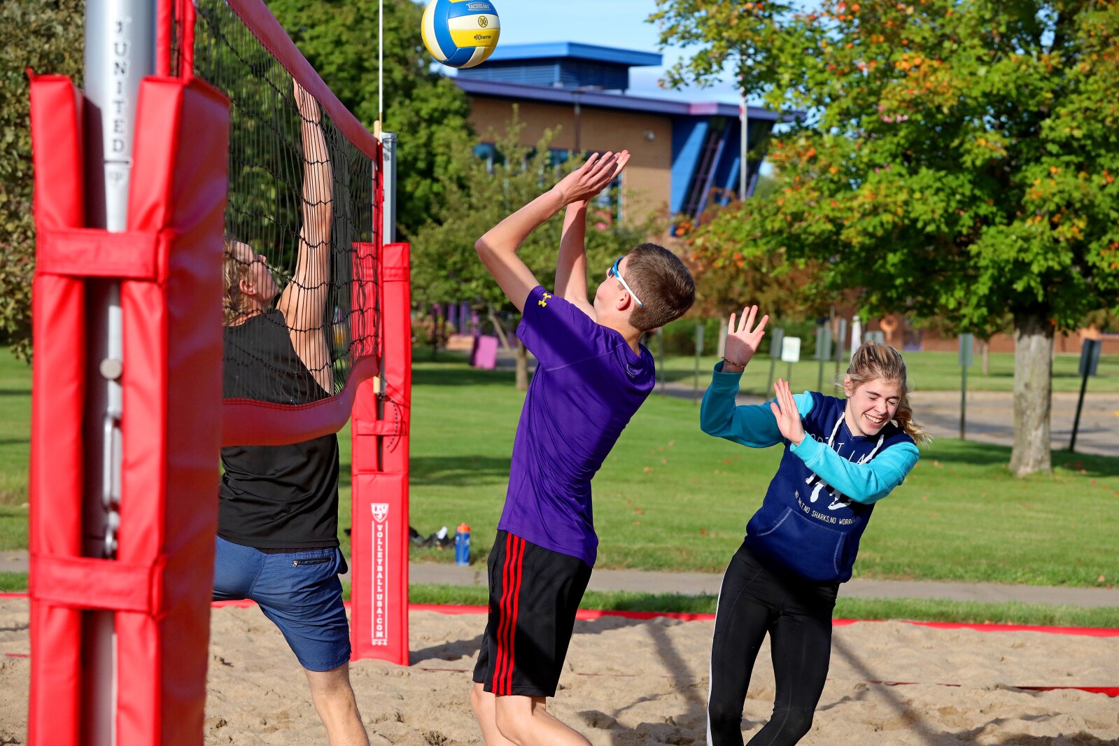 Volleyball players compete outside on the sand volleyball courts at CLC.