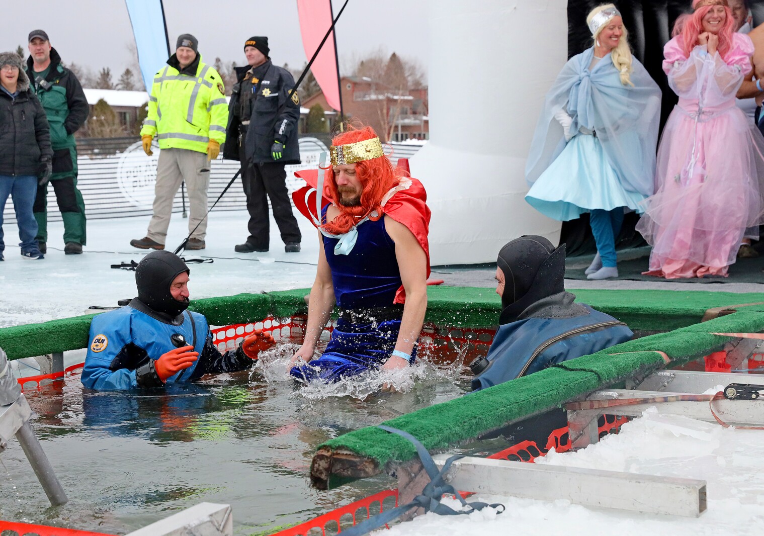 People jump into the water during the Polar Plunge event on Pelican Lake.