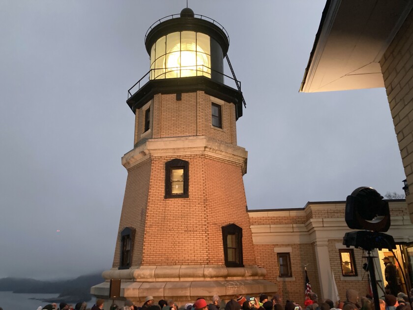 A lit beacon at a lighthouse during a ceremony.