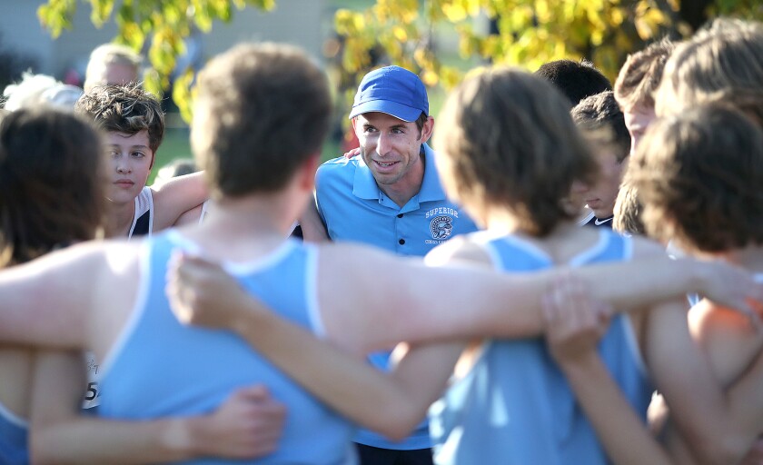 Superior head cross country coach Lee Sims, center, talks to his Spartan boys team before the Lake Superior Conference meet