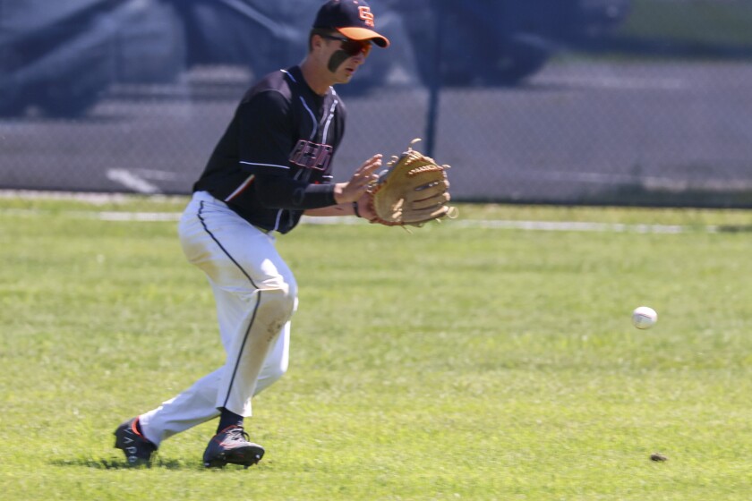 High school boys in black and orange uniforms with white shorts play baseball