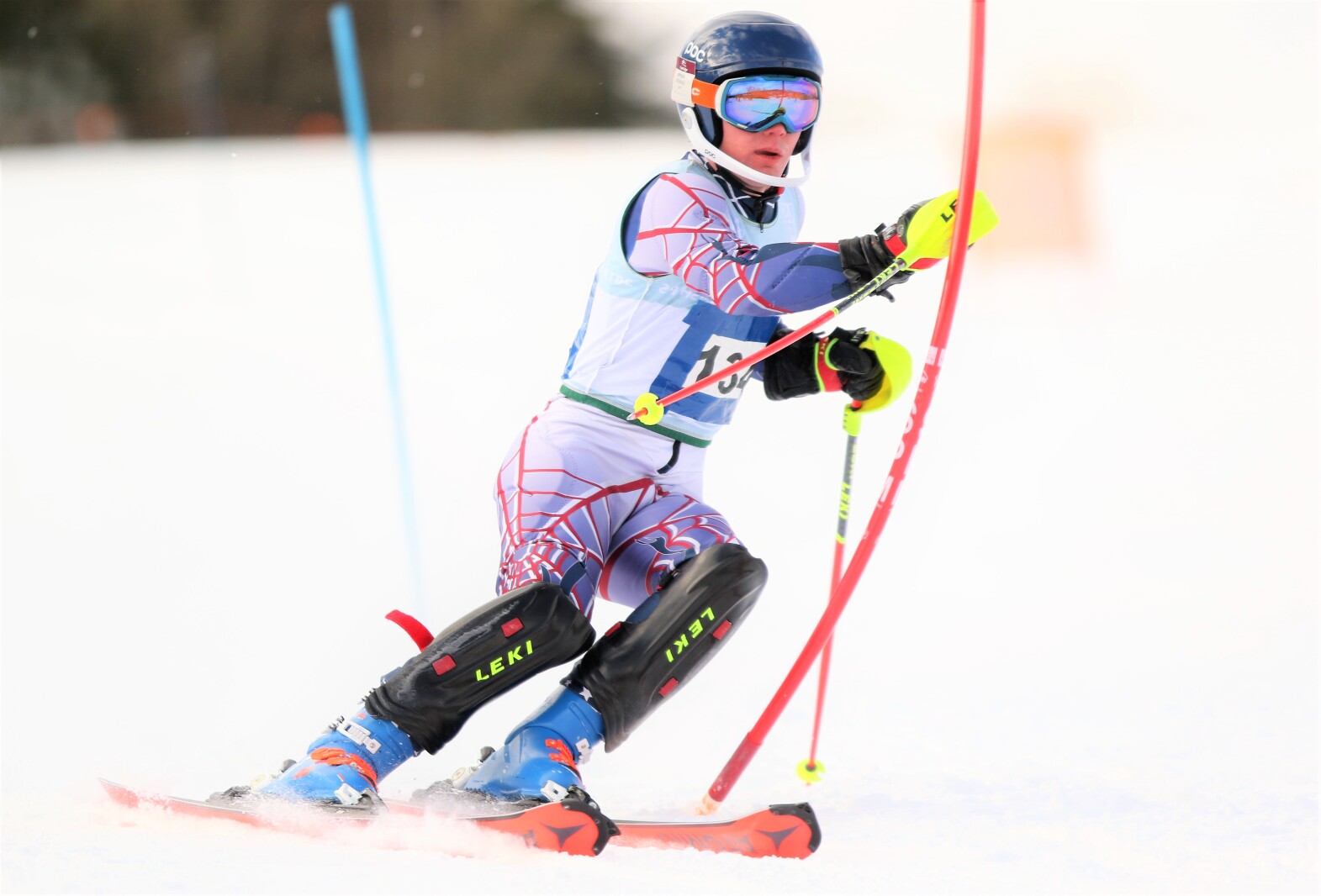 A downhill skier moves around a gate.