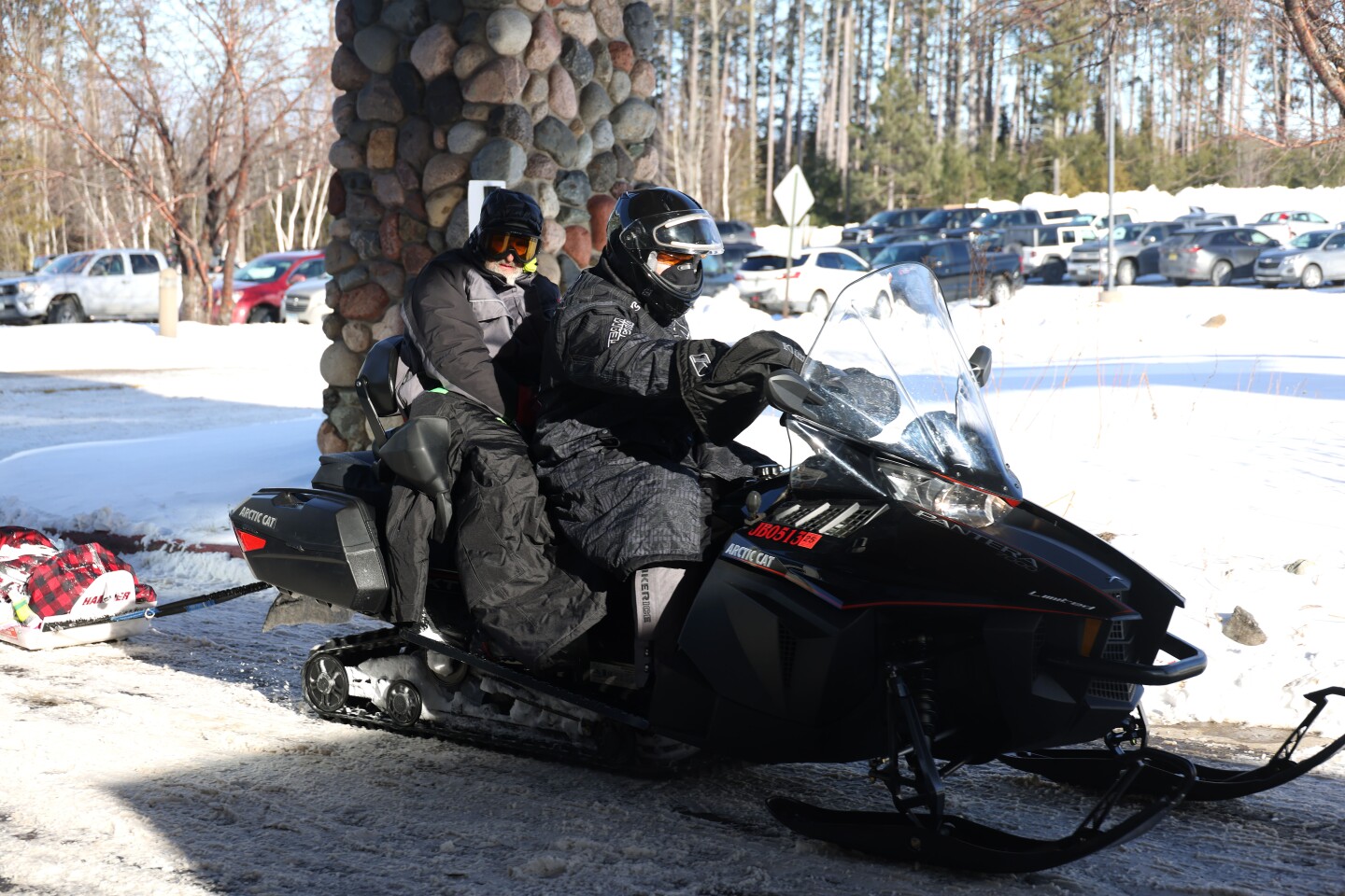 Racer rides on the back of a snowmobile
