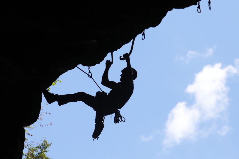 Adam Dailey does a mixed climbing demo at Flock to the Rock in the abandoned railroad tunnel at Ely's Peak Saturday. Dailey used climbing shoes with spikes and ice axes to climb 70 feet. The technique he used is called dry tooling because he used tools meant for ice and water to climb dry rock.Tyler Schank / tschank@duluthnews.com