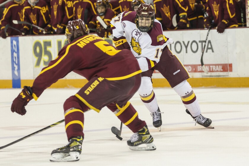 College hockey players play game in indoor arena