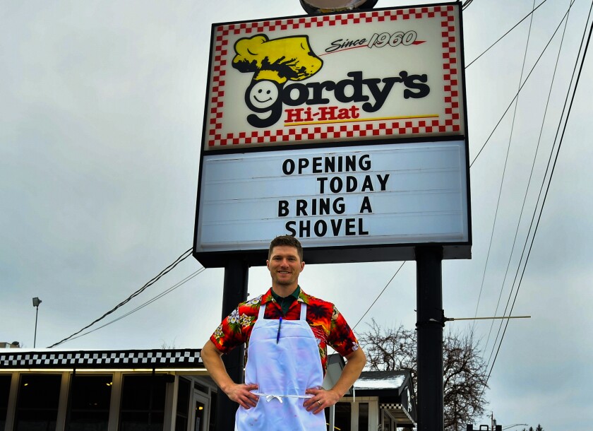Man stands in front of a restaurant