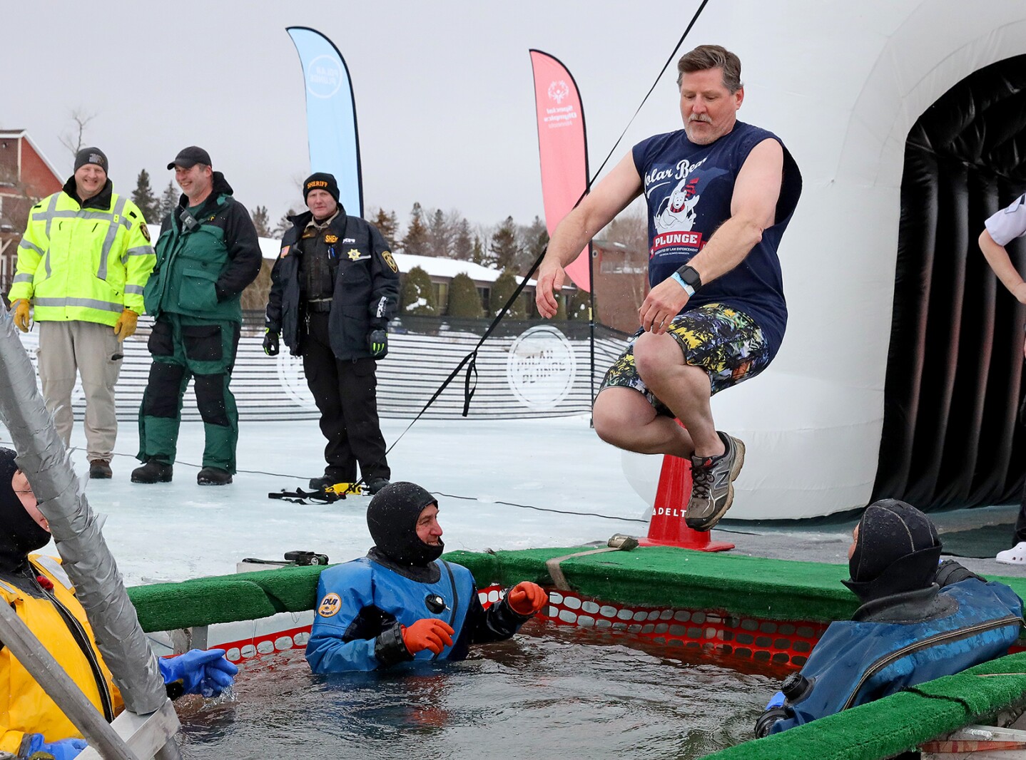 People jump into the water during the Polar Plunge event on Pelican Lake.