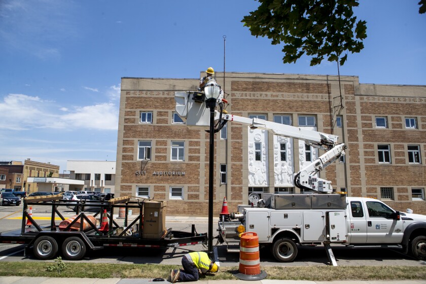 Willmar Municipal Utilities workers Jordan Stulan, below, and Zach Larson, above, work to install new street lights along 6th Street SW in downtown Willmar on Wednesday, June 29, 2022.