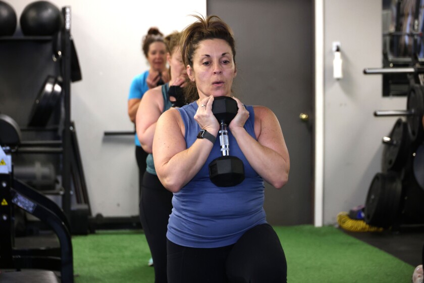 Woman carries dumbbell during fitness class