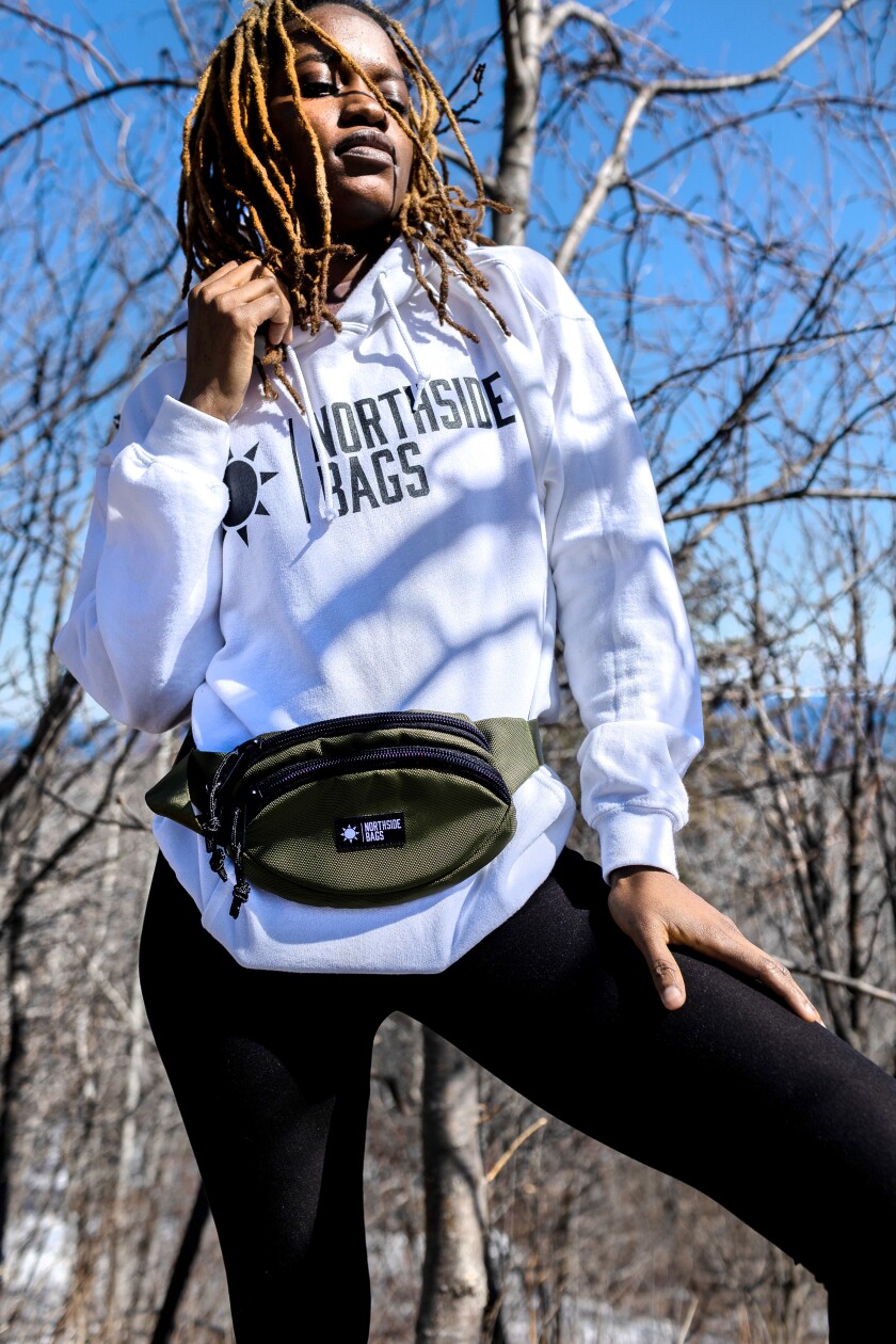 A model wears a Northside Bags fanny pack in a wooded area.