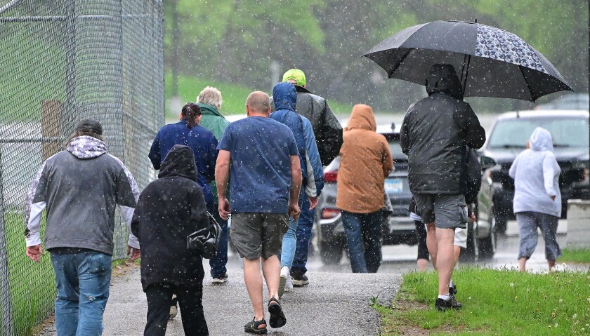Fans leaving the Warrior boys lacrosse match in the rain.