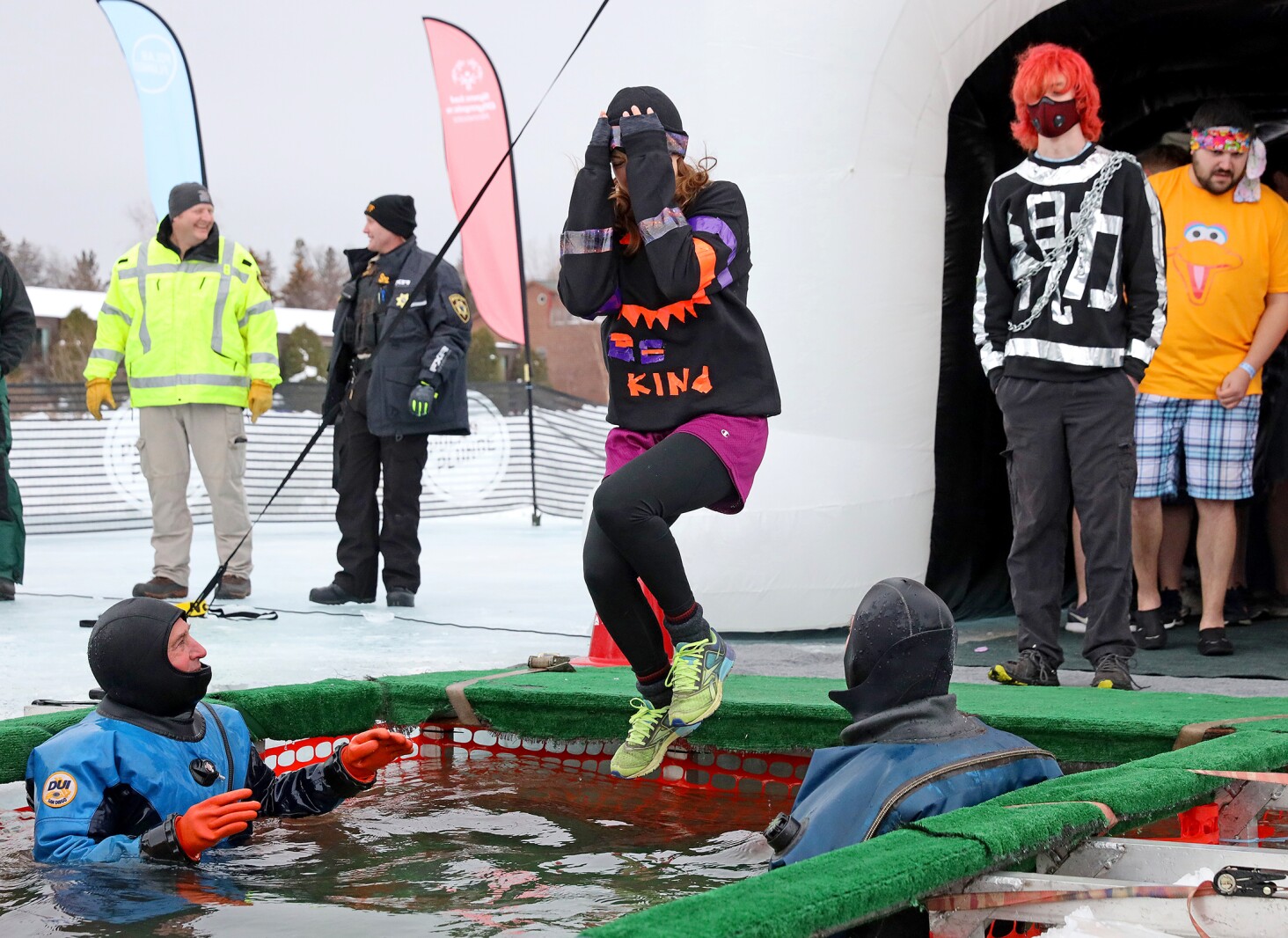 People jump into the water during the Polar Plunge event on Pelican Lake.