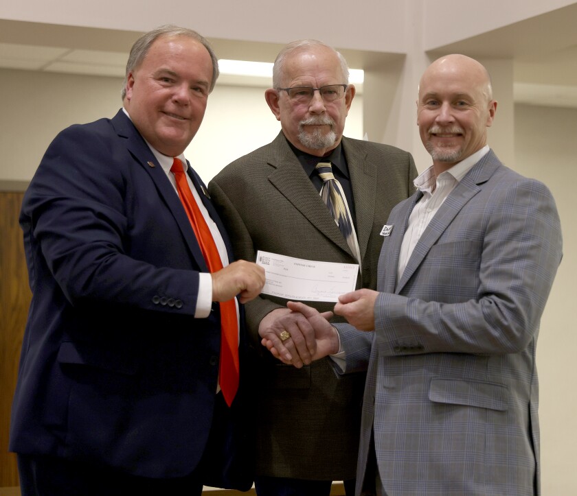 Greg Raymo, left, president of First State Bank Southwest, presents an award check to Sunset Hospice Cottage Board of Directors President David Serrano, right, as the hospice was the charity chosen by Community Pride Award winner Michael Eggers, center, owner of Mick's Repair. Eggers has been a member of the Elks for 20 years, earning an Officer of the Year and an Elk of the Year award during that time, and a member of the American Legion for 10 years. He has served on the Police Civil Service Commission. He spent six years on the King Turkey Day Board of Directors and was a member of the race team in 2002 and 2007.