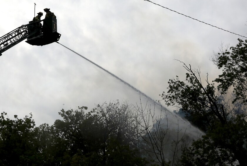 Duluth Fire Captain Rob Mesedahl, left, and firefighter Nick Ellingson shoot water onto a fire at West 1st Street and Piedmont Avenue