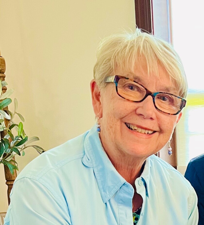Elder woman smiles with glasses and short hair
