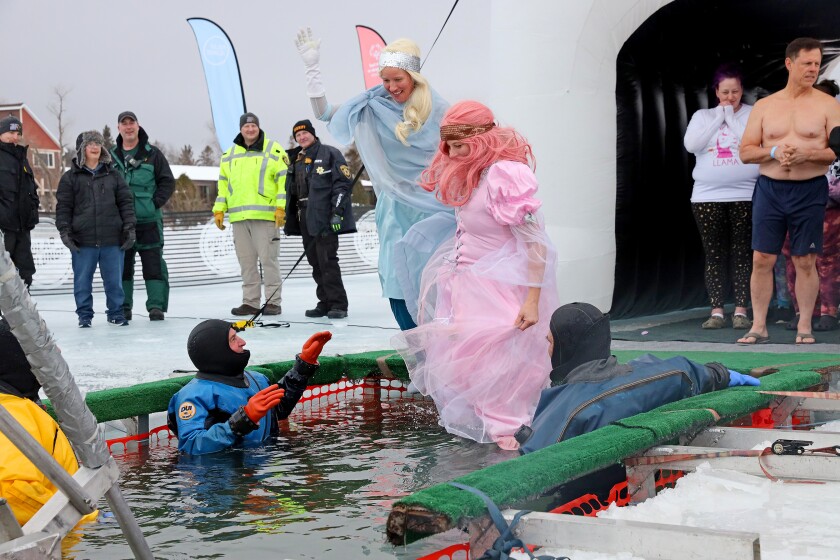 People jump into the water during the Polar Plunge event on Pelican Lake.