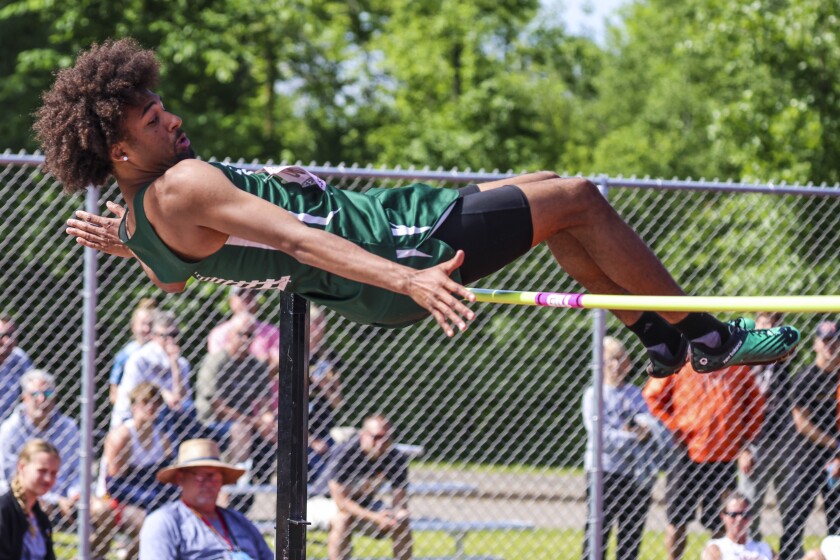 High school athletes compete in track and field events at outdoor stadium