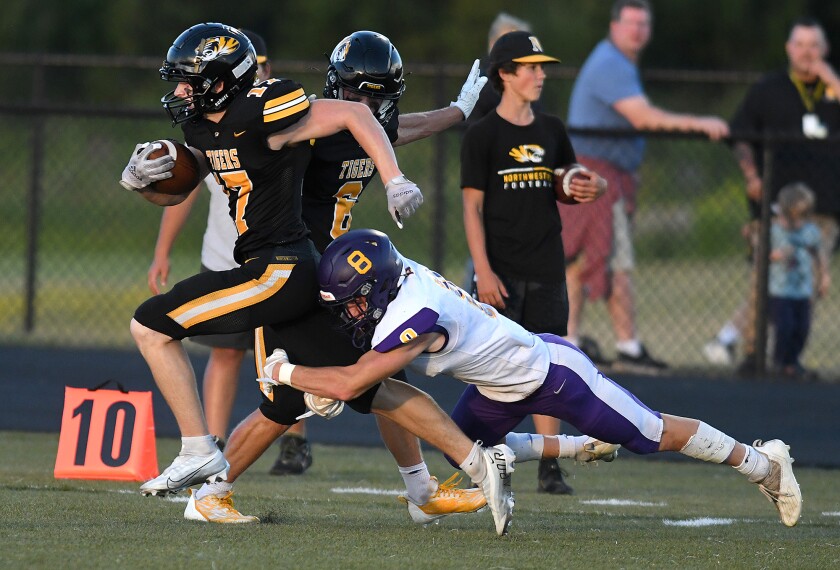 Northwestern’s Reid Kreuser (17) gets tripped up by Ashland’s Ethan Petersen (8)