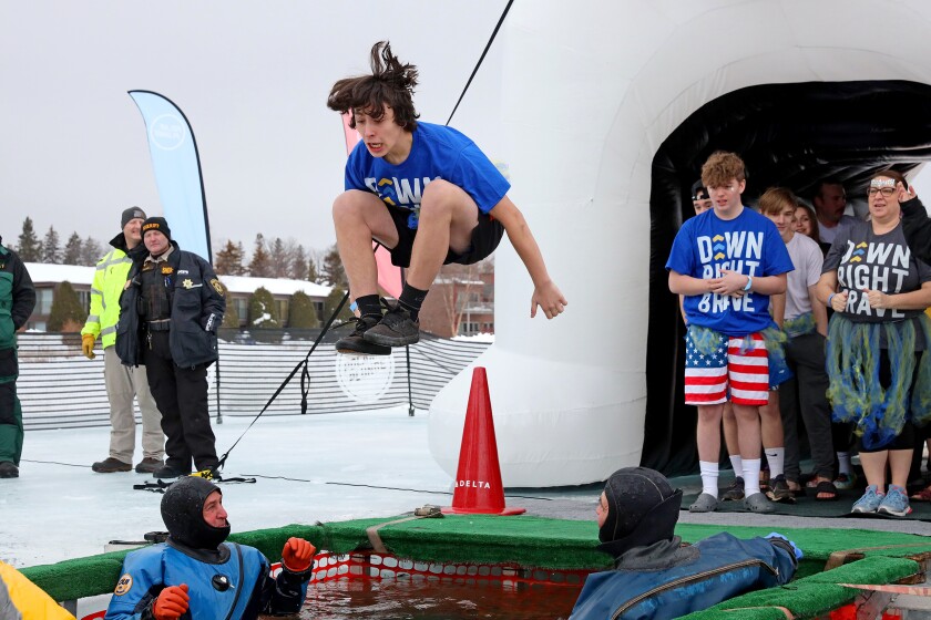 People jump into the water during the Polar Plunge event on Pelican Lake.