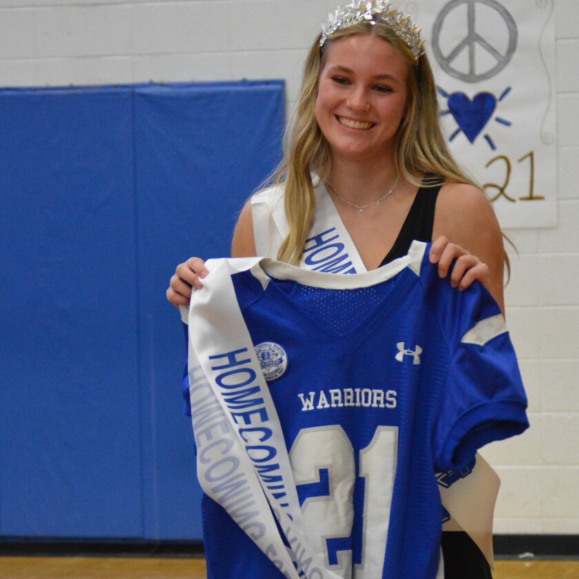 A girl, selected as Brainerd Homecoming Royalty, holds up the football jersey of the boy who was also seletced as homecoming royalty but could not attend the ceremony.