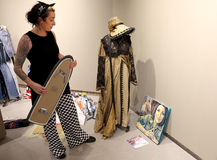 Artist looks at painting of her.