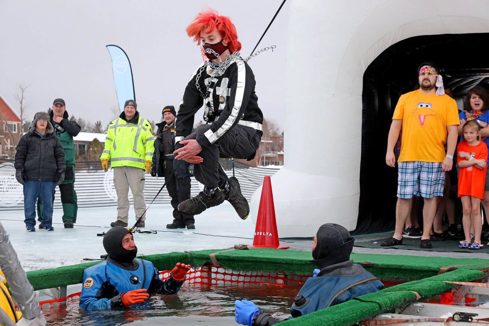 People jump into the water during the Polar Plunge event on Pelican Lake.