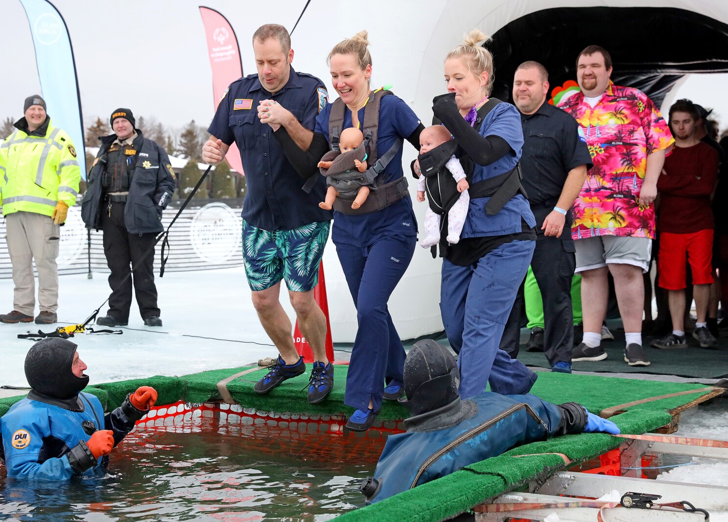 People jump into the water during the Polar Plunge event on Pelican Lake.