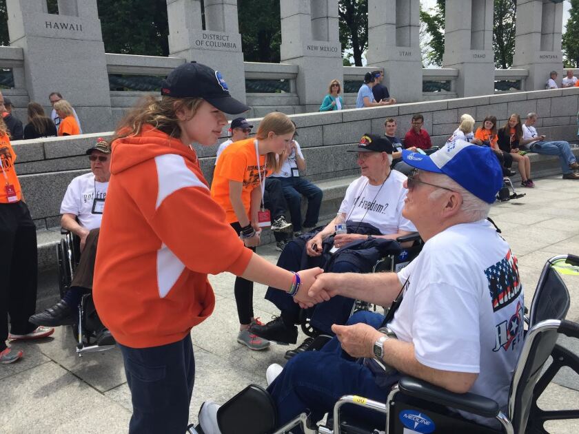 Horizon Middle School student Sophia Schuetz visits with Korean War Veteran Glenn Mauer in Washington, D.C., on Monday, while seventh-grader Thalia Christenson, in back, talks with another Honor Flight Veterans at the World War II M Memorial. Wendy Reuer / The Forum