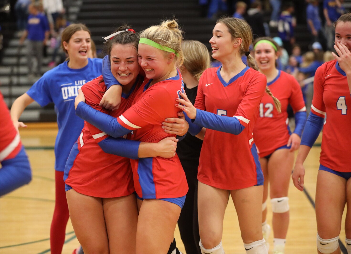 Pequot volleyball players hug and celebrate.