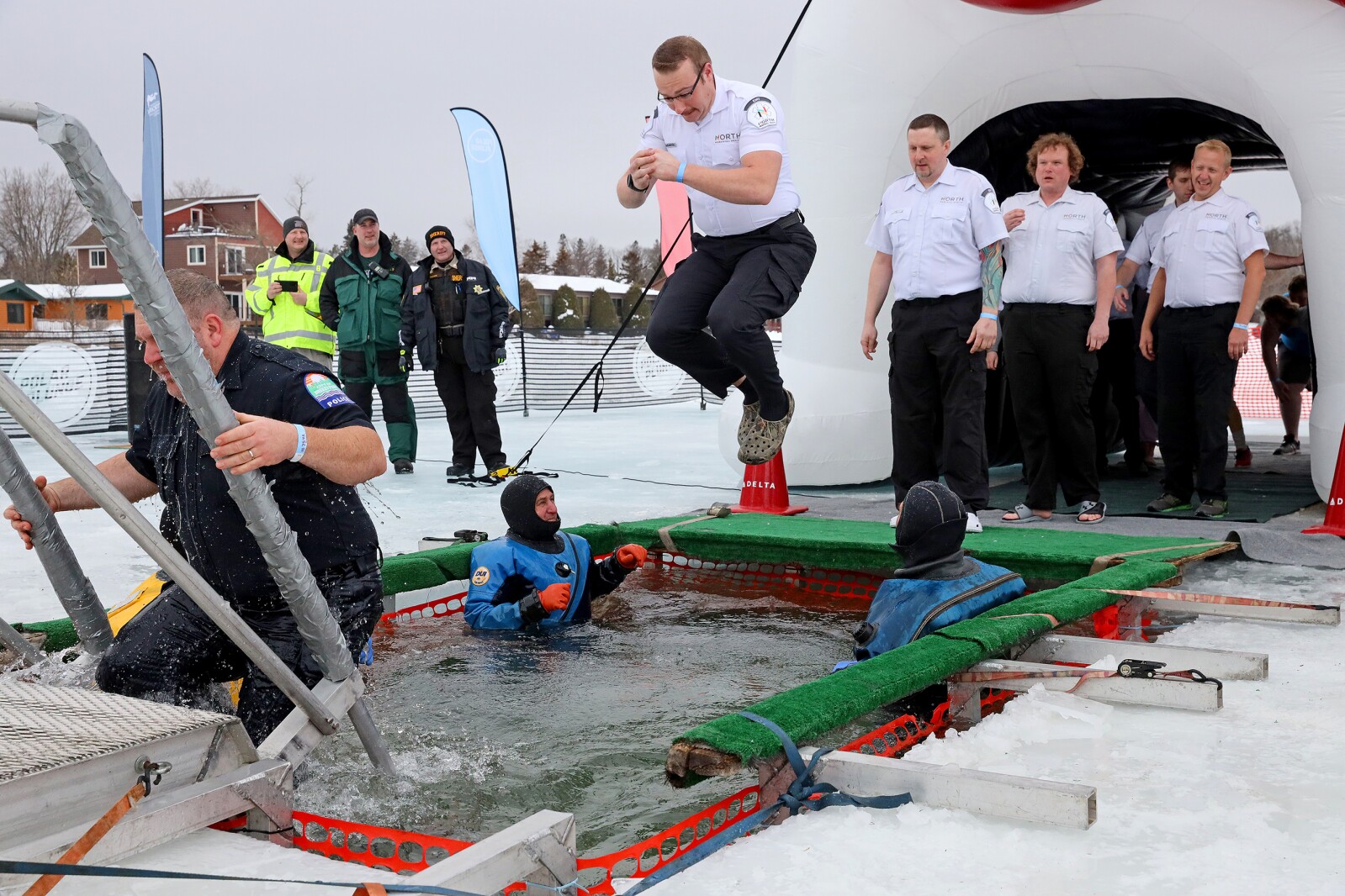 People jump into the water during the Polar Plunge event on Pelican Lake.