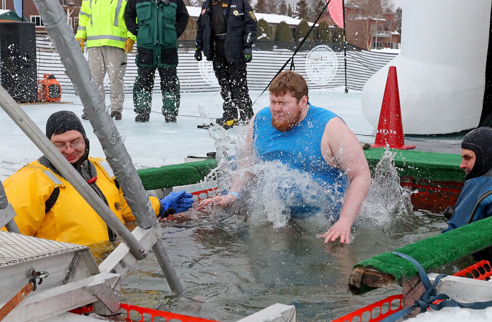 People jump into the water during the Polar Plunge event on Pelican Lake.