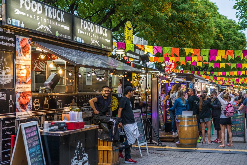 Food trucks and people at a street food market festival on a sunny day