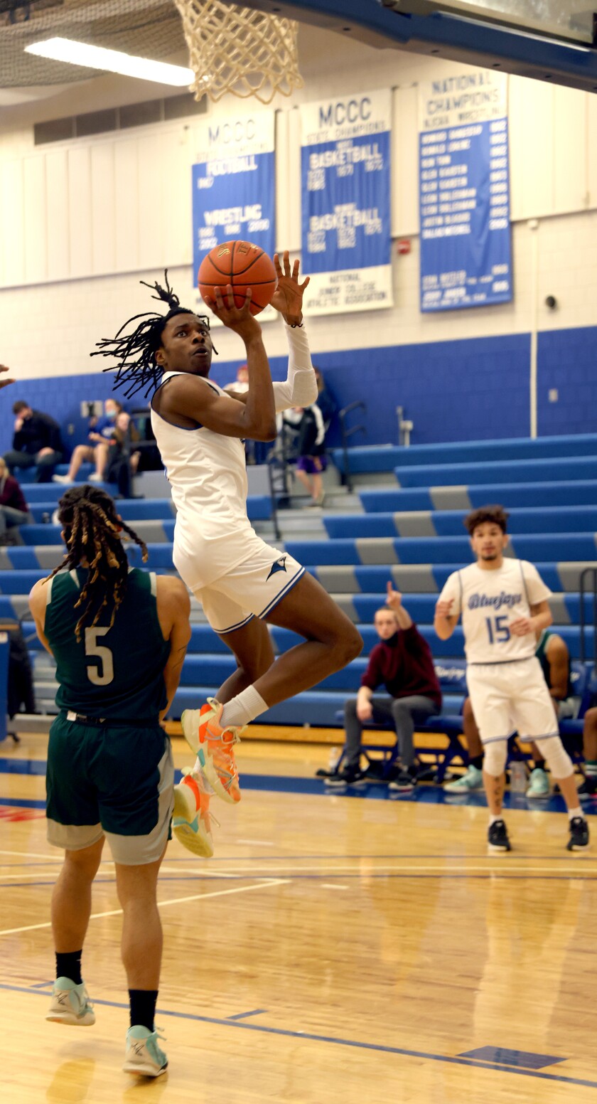 Minnesota West Blue Jays Steve Ndumbe leaps past St. Cloud Technical & Community College Cyclones guard Jason Fagin (5) post for two points as teammate Jacob Dorian (15) watches from the three point line Monday afternoon in Worthington.