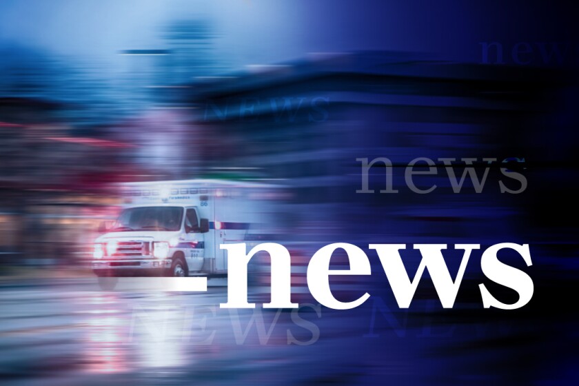 An ambulance speeds though an urban setting with blurry streaks seen. The words news are overlaid on the image in white.