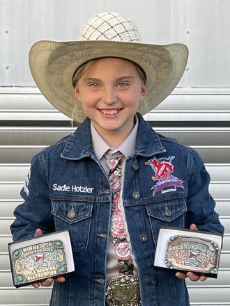 Sadie Hotzler with her rodeo championship buckles.