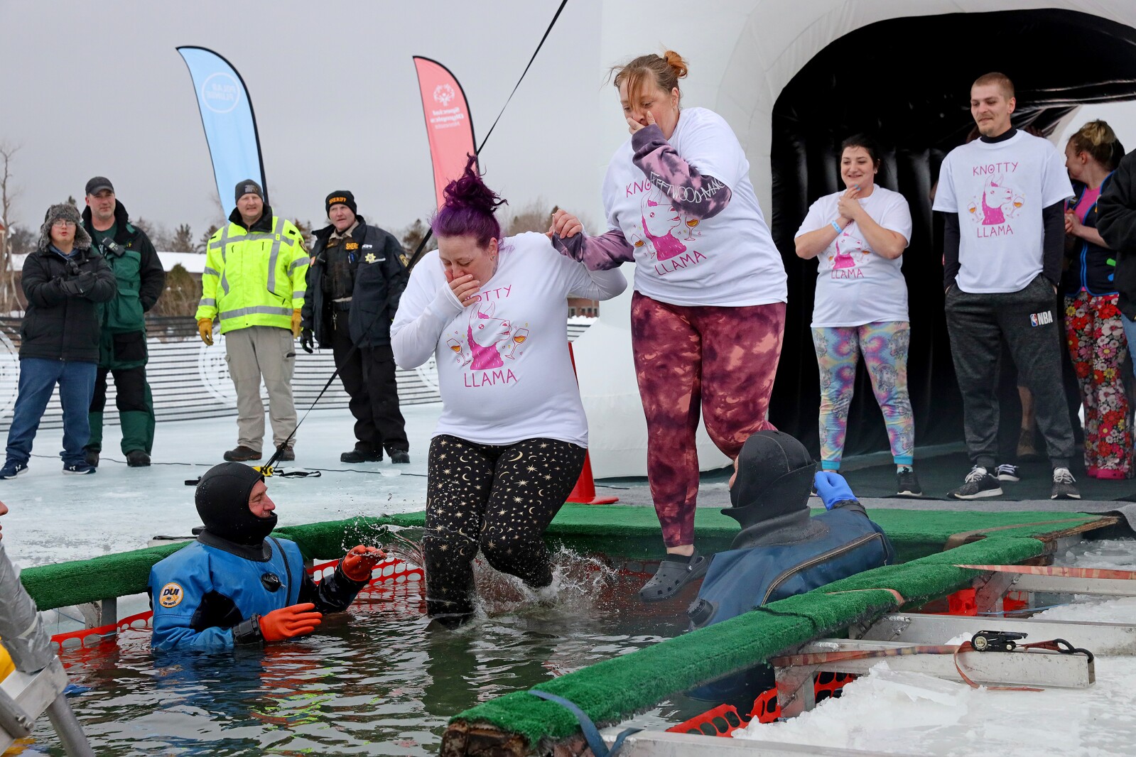People jump into the water during the Polar Plunge event on Pelican Lake.