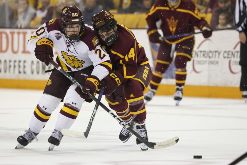 College hockey players play game in indoor arena