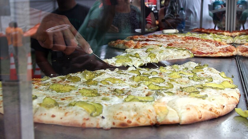 Pickle pizza being served.