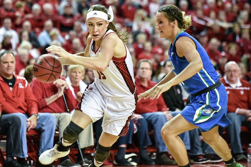 South Dakota's Kelly Stewart, left, drives to the basket as Florida Gulf Coast's Jamie Gluesing, right, during the WNIT championship game on Saturday at the DakotaDome in Vermillion. (Matt Gade/Republic)