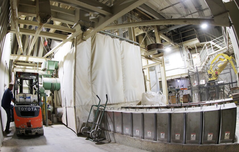A feed manufacturing plant includes a pellet-making area shrouded for sound, and a "micro-system" of boxes of ingredients that can be incorporated by computer, without touching, and a robotic sack stacker at right.