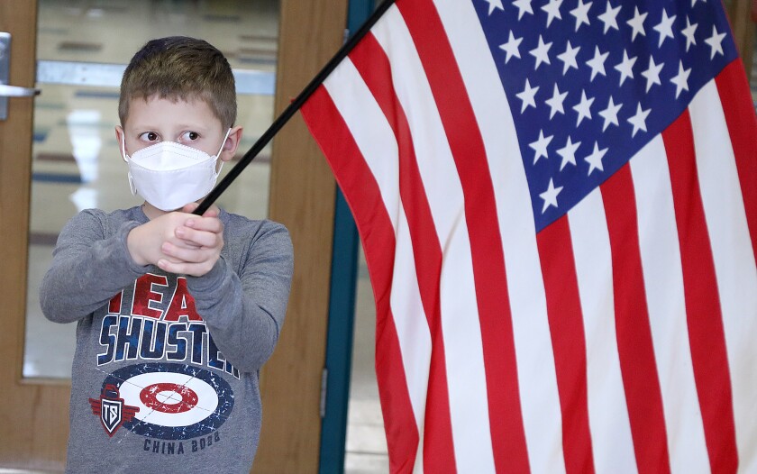 Luke Shuster holds the United States flag with two hands