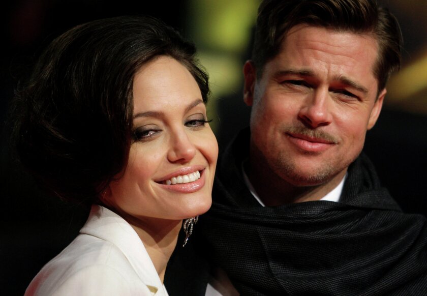 U.S. actors Brad Pitt and his partner Angelina Jolie pose for photographers on the red carpet at the German premiere of the movie "The Curious Case of Benjamin Button" in Berlin January 19, 2009. REUTERS/Hannibal Hanschke/File Photo TPX IMAGES OF THE DAY
