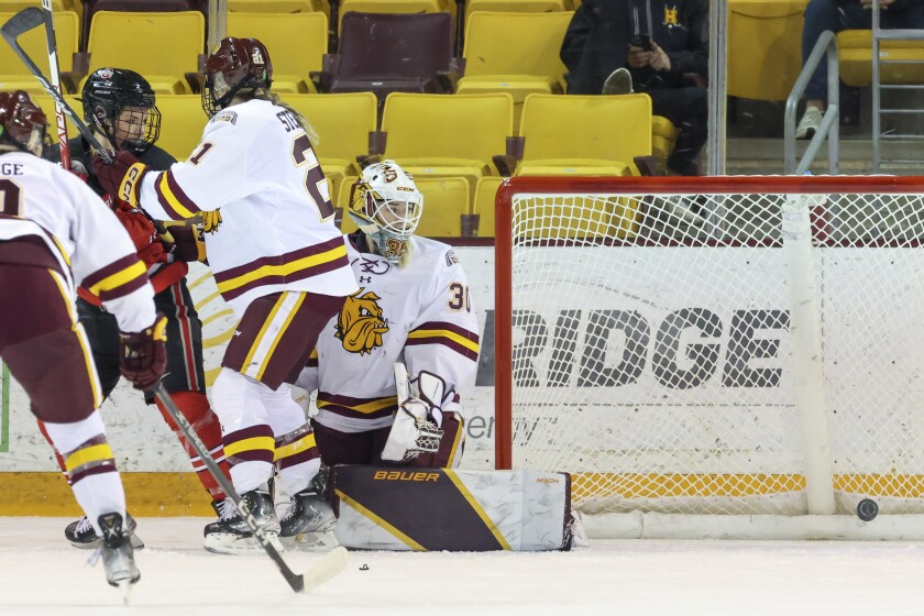 women hockey players compete during game