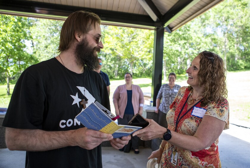Karon White, who serves as the 8th Judicial District Treatment Coordinator, talks with Gerald Cloutier Jr. about how different he looks today versus when his intake photo was taken in 2019 following his graduation from 8th Judicial District Drug Court at Robbins Island Regional Park on June 8, 2022.