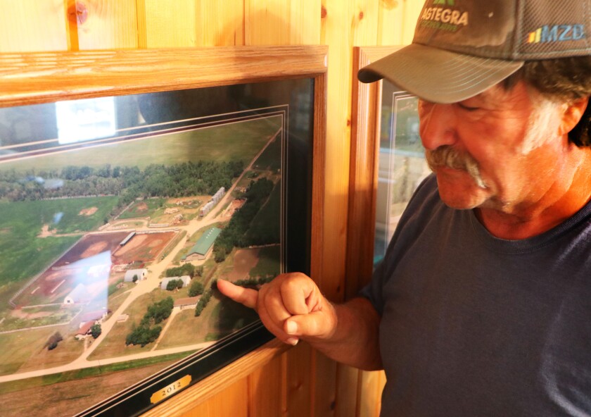 A farmer in his 60s points out on a framed, aerial farm photo, where his family settled in 1882 -- seven years before South Dakota statehood.