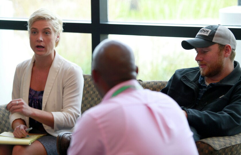 Brandi Jude (left), a veteran from Bismarck, discusses a team decision simulation with Timothy Jones (center), Pensacola, Fla., and Keith Homstad, East Grand Forks, on Thursday at a entrepreneurial workshop for disabled veterans. photo by Eric Hylden/Grand Forks Herald
