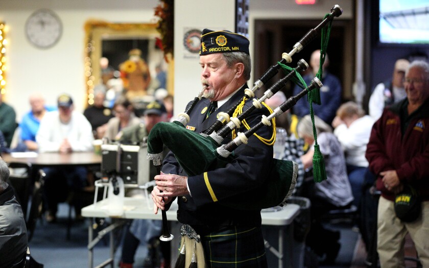 A man playing bagpipes at a Veterans Day event.