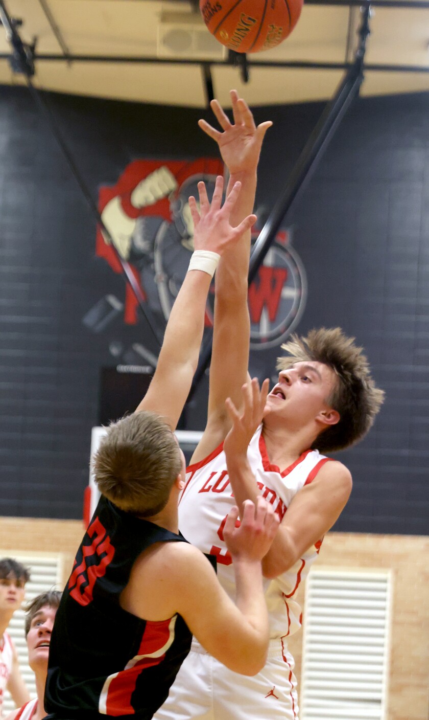 Luverne Cardinals Guard Carter Sehr (5) jumps clear of Trojans Kaleb Knothe (33) during a Monday evening game in Worthington.