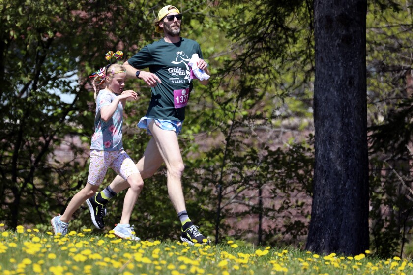 Two runners near the end of the Girls on the Run Minnesota 5K event Sunday, June 5, 2022, at Leif Erickson Park.